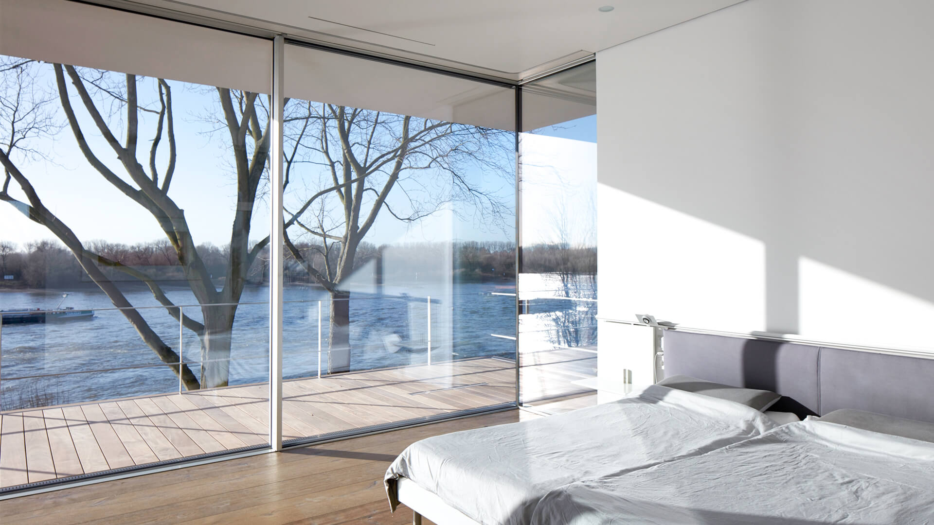 a bedroom with huge windows and lot's of sunlight